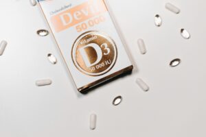 Flat lay of Vitamin D3 supplement box and capsules on a light background.